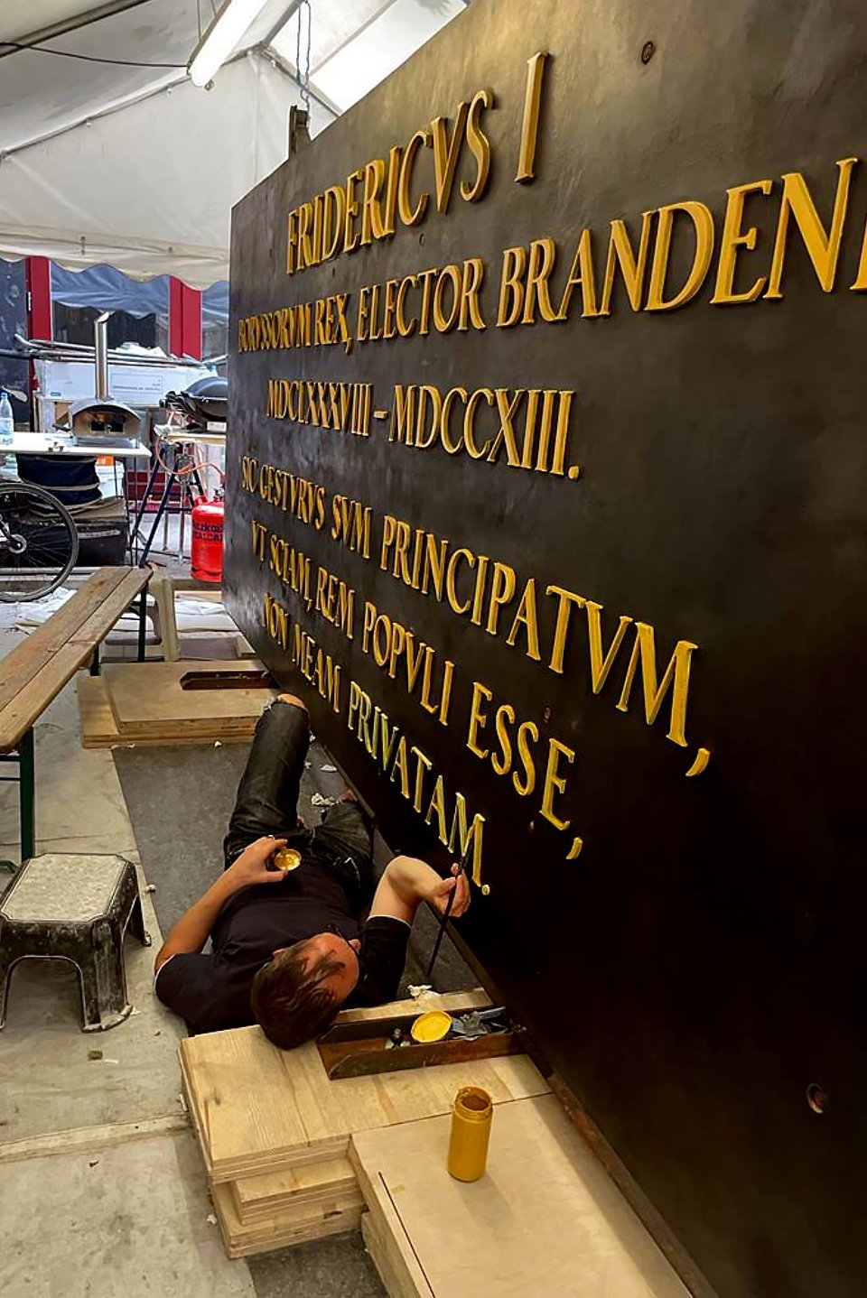 Gilding of the letters on the bronze plaques